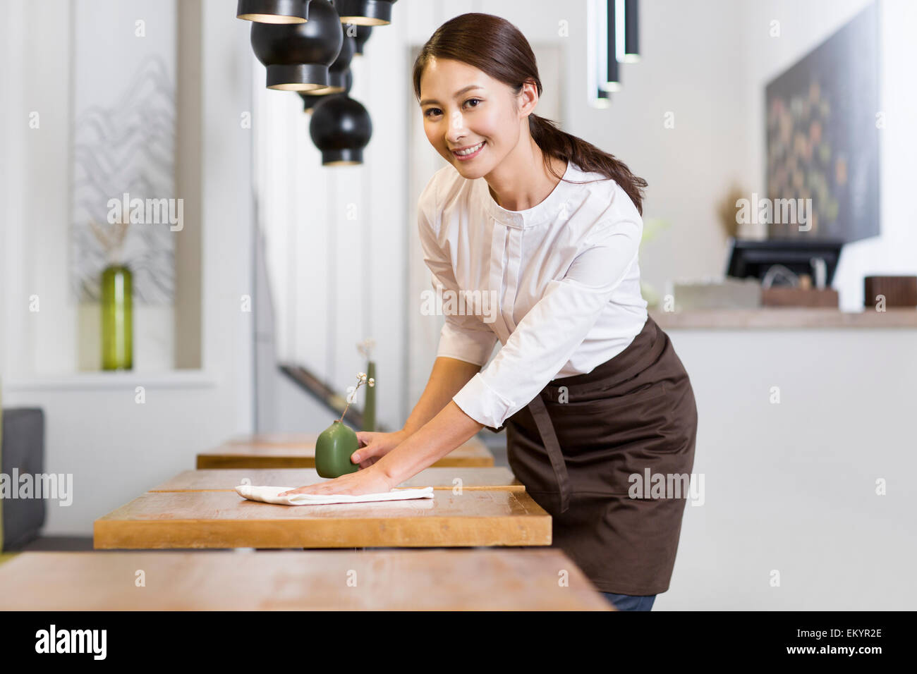 Jeune serveuse table essuyage Banque D'Images