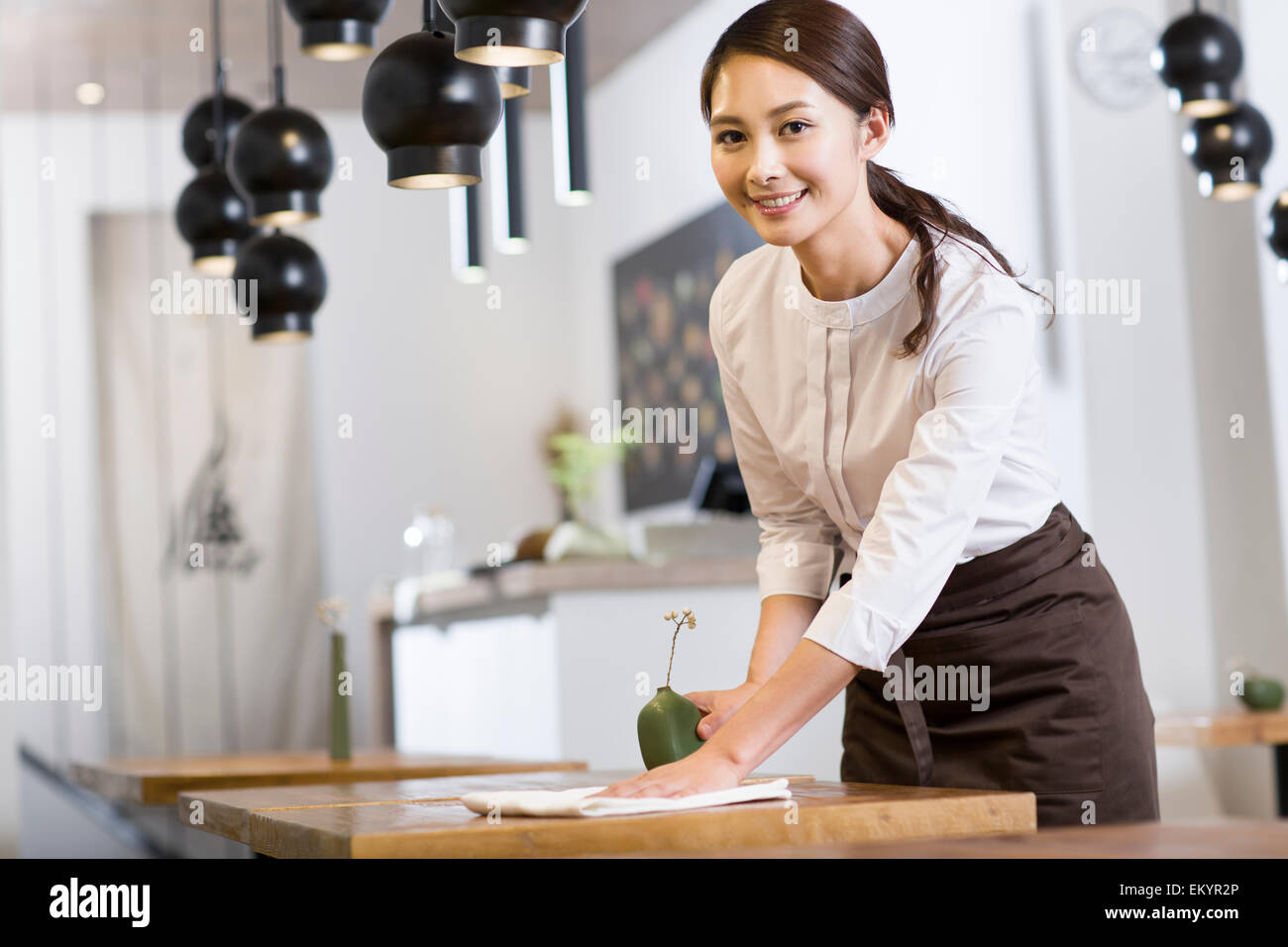 Jeune serveuse table essuyage Banque D'Images