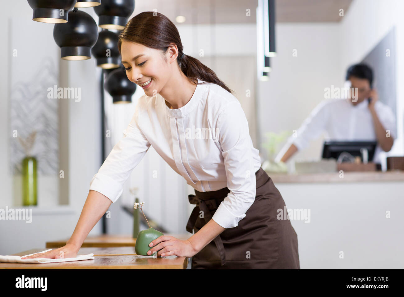 Jeune serveuse table essuyage Banque D'Images