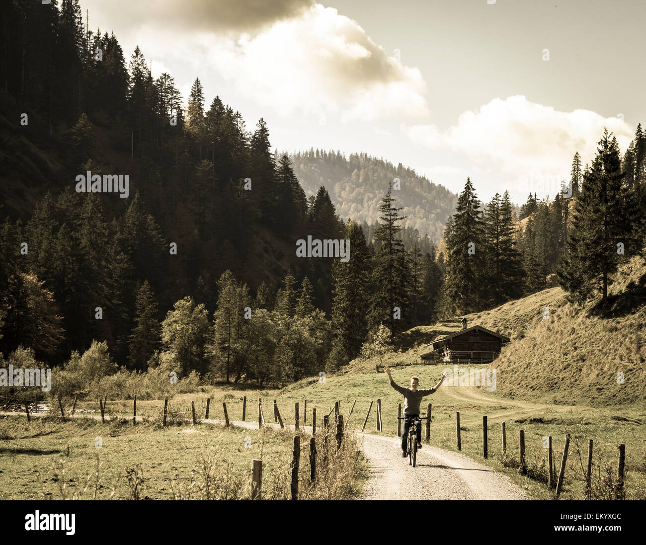 Jeune homme de rouler à vélo sans les mains, paysage de montagne, Valepptal Spitzingsee,, Bavière, Allemagne Banque D'Images