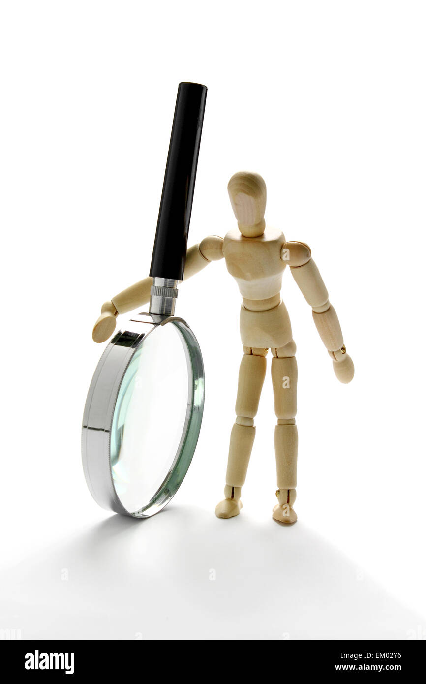 Mannequin en bois holding magnifying glass Banque D'Images