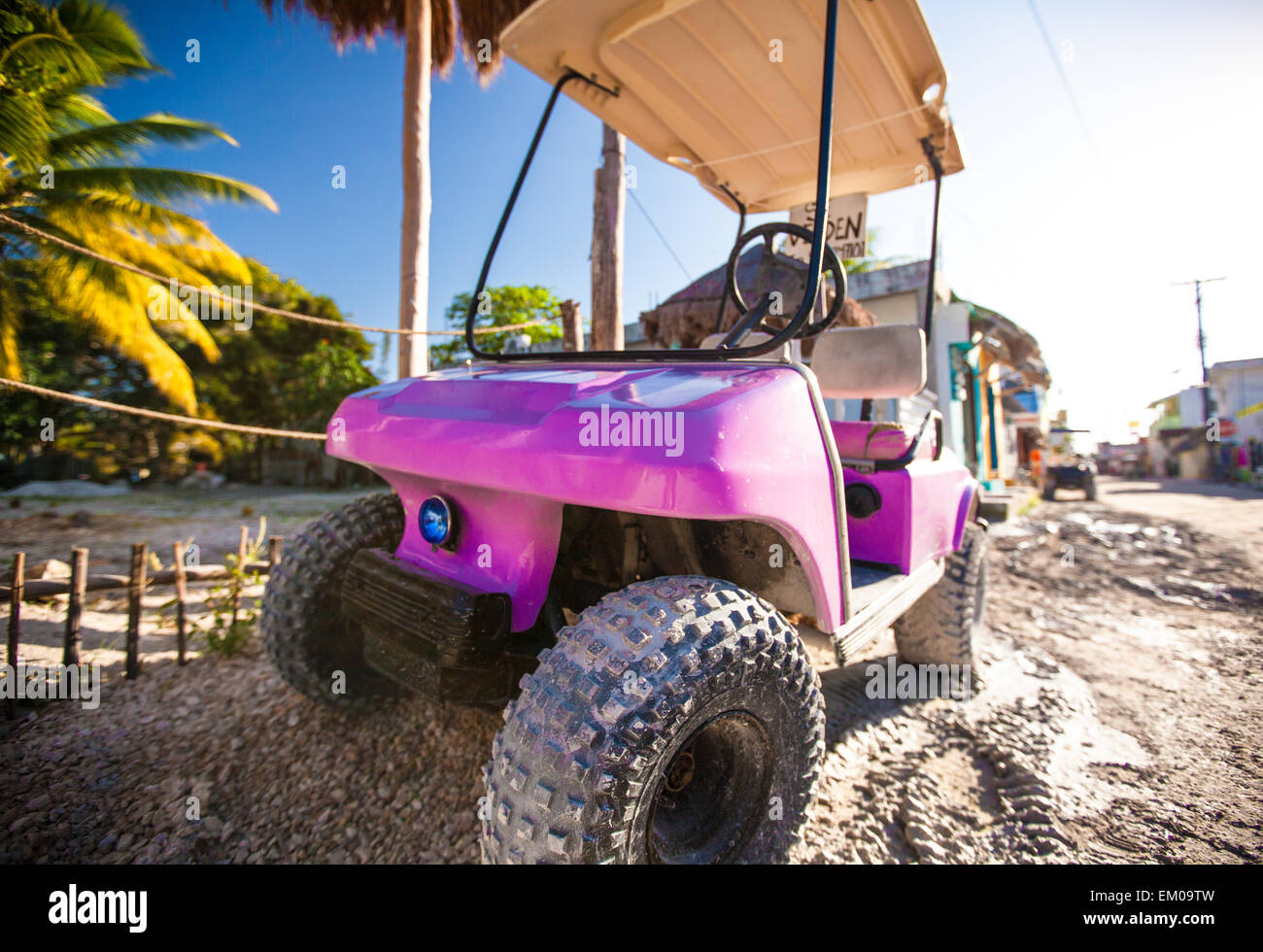 Drôle de voiture de golf de roses dans la rue sur une île tropicale Banque D'Images