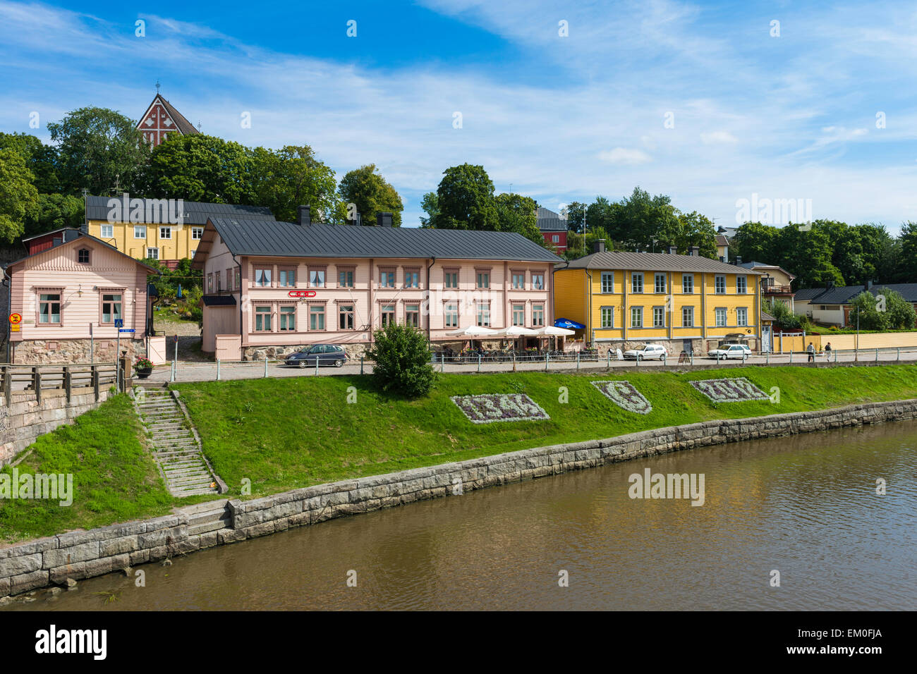 Les bâtiments, dont Riverside cafe, sur la rivière Porvoonjoki dans la ville médiévale de Porvoo, Finlande. Cathédrale de Porvoo sur hill. Banque D'Images