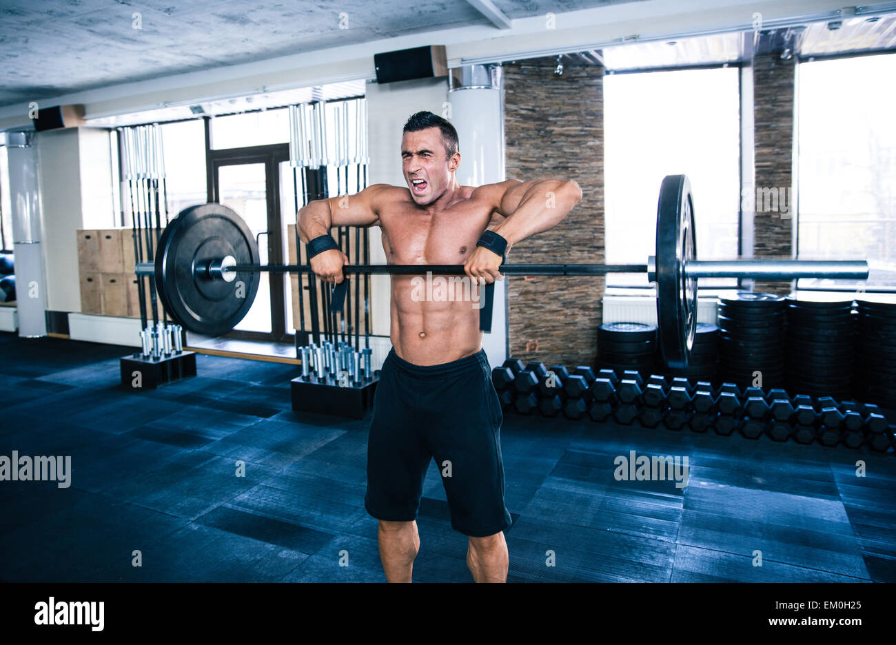 Monter man lifting barbell at gym Banque D'Images