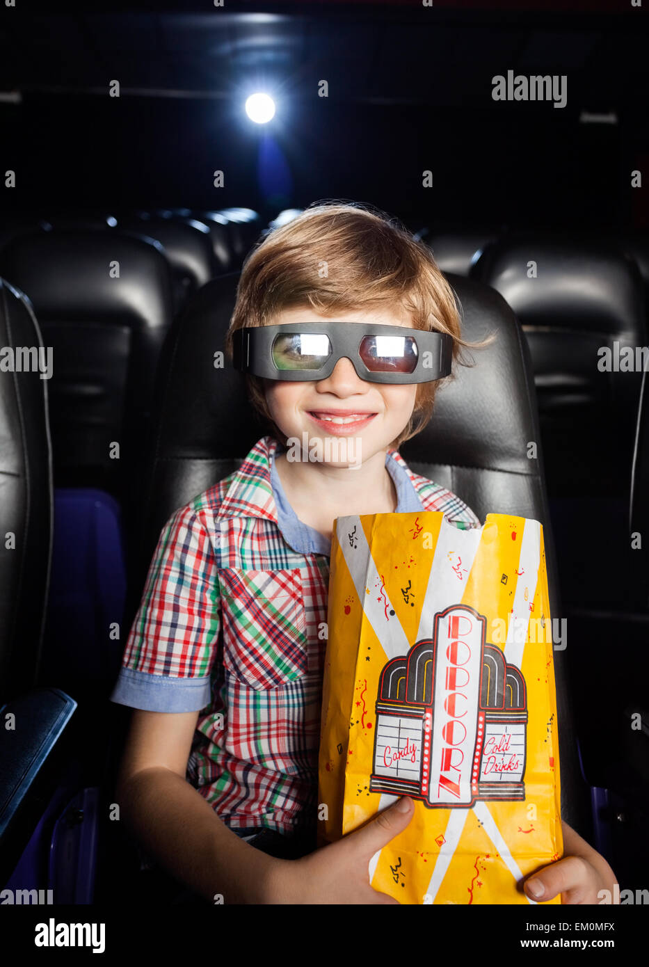 Smiling boy holding popcorn au théâtre 3d Banque D'Images