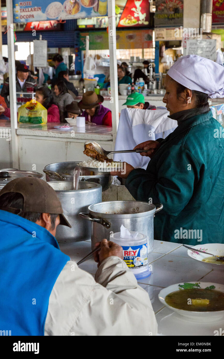 Pérou, Cusco, Marché de San Pedro. Cuire servant le déjeuner pour un client dans le domaine de la restauration le marché. Banque D'Images