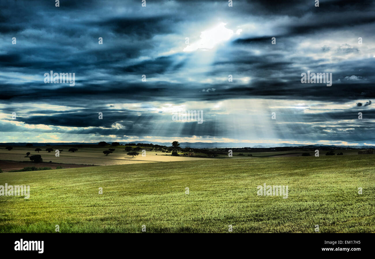 Paysage rural, ciel dramatique, et les rayons du soleil la lumière sur les domaines de la campagne d'Olivença, Badajoz, Estrémadure, Espagne Banque D'Images