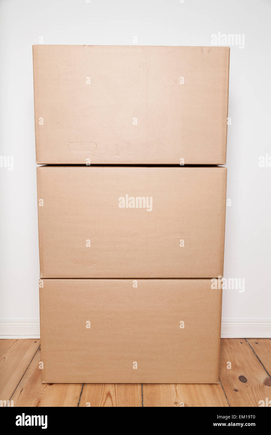 Pile de cartons de déménagement sur plancher en bois Banque D'Images