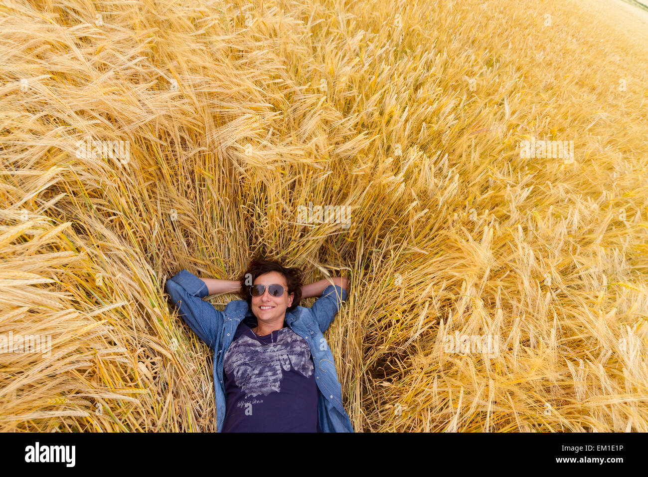 Femme au repos dans un champ de blé. Village de Peñafiel. Ribera del Duero région. Valladolid. Castille et Leon. L'Espagne, l'Europe. Banque D'Images