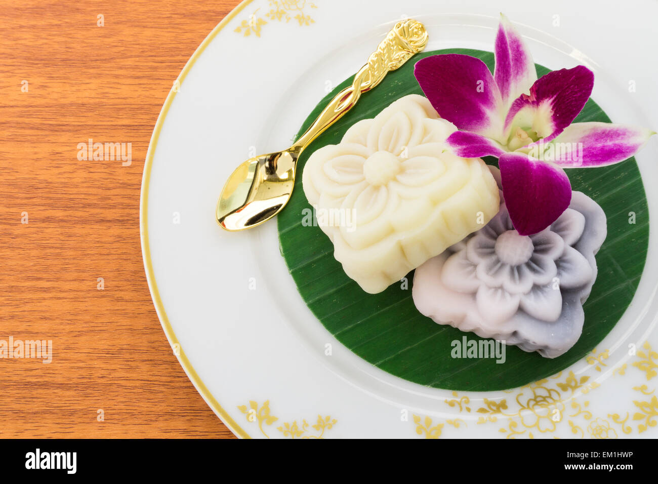 Deux gâteaux japonais placé sur des feuilles de banane avec cuillère d'Or et orchidée, fleur Banque D'Images