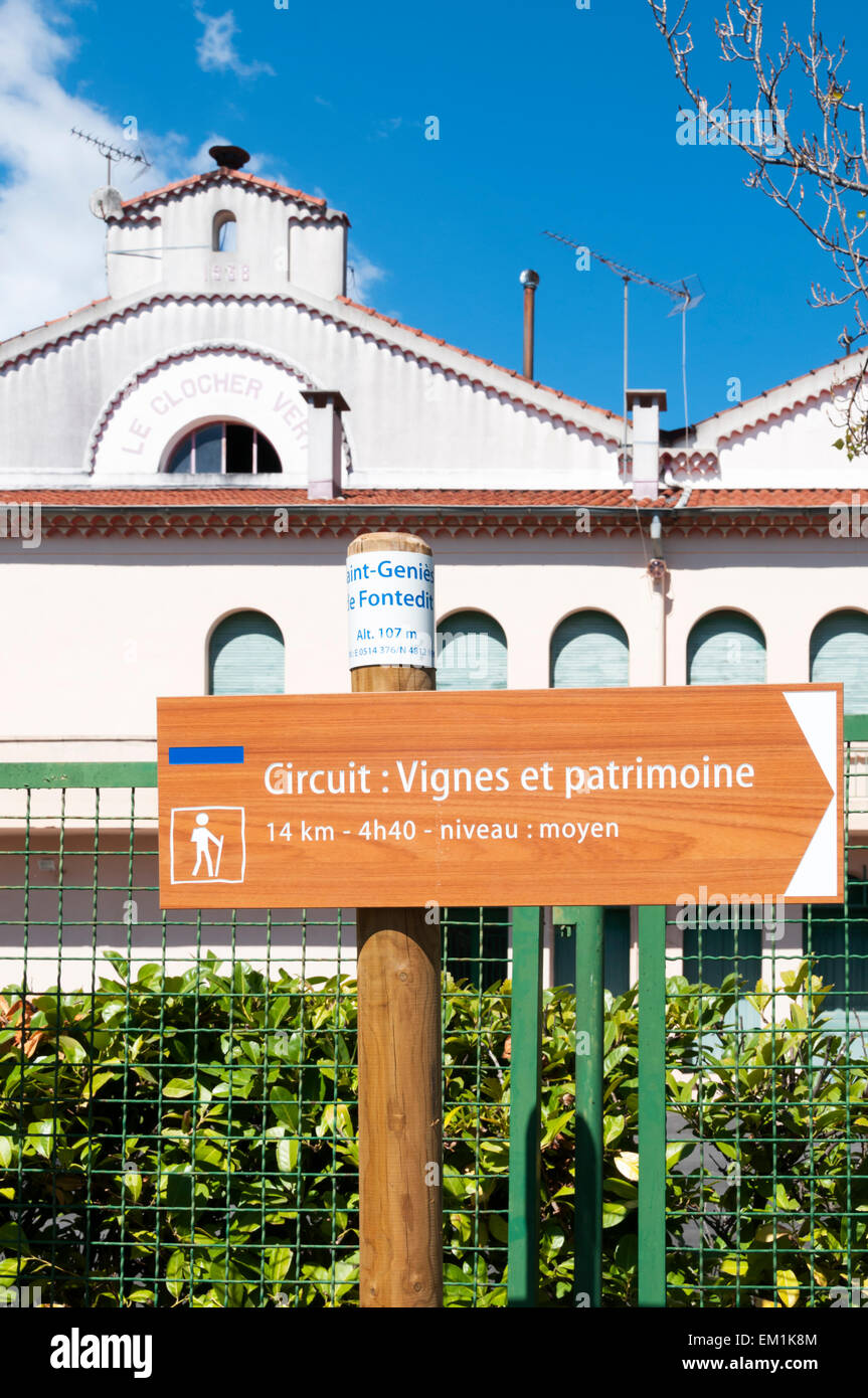 Inscrivez-vous pour un circuit à pied dans le village de St Genies de Fontedit, devant le clocher Vert les producteurs de vin Banque D'Images