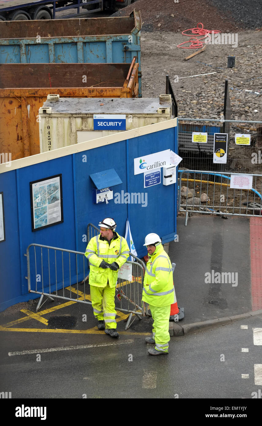 Une paire de construction site gatemen attendant de rencontrer des livraisons. 13 Mars 2015 Banque D'Images