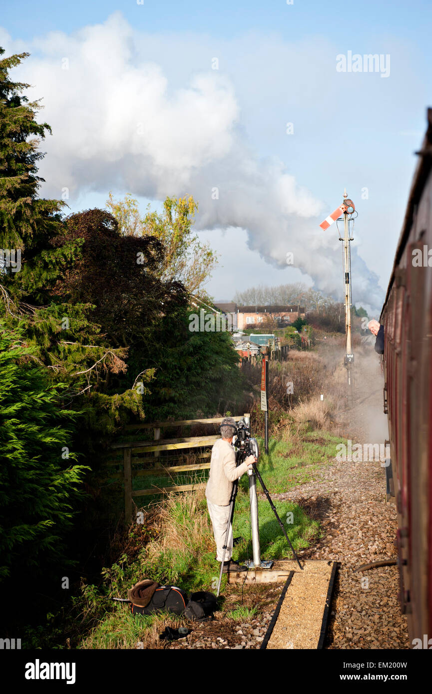 Arrêter le quadrant inférieur vu de signaux de sémaphore un train à vapeur tandis qu'un photographe enregistre le mouvement d'un pied crossing Banque D'Images