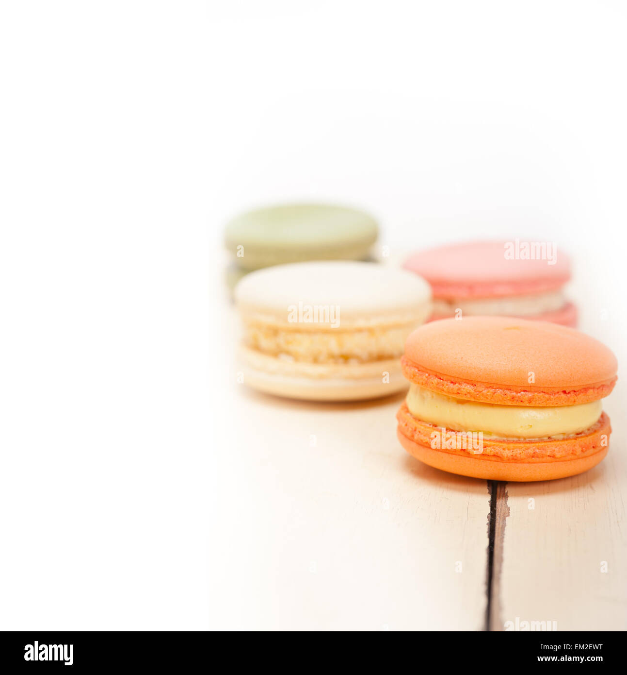 Macarons français colorés sur une table rustique en bois blanc Banque D'Images