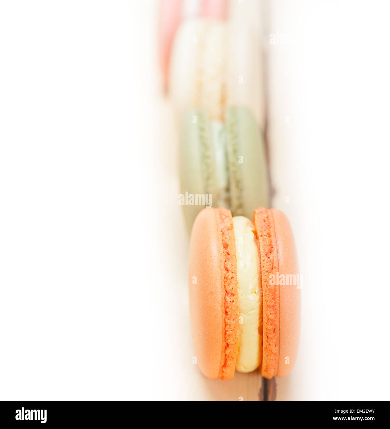 Macarons français colorés sur une table rustique en bois blanc Banque D'Images