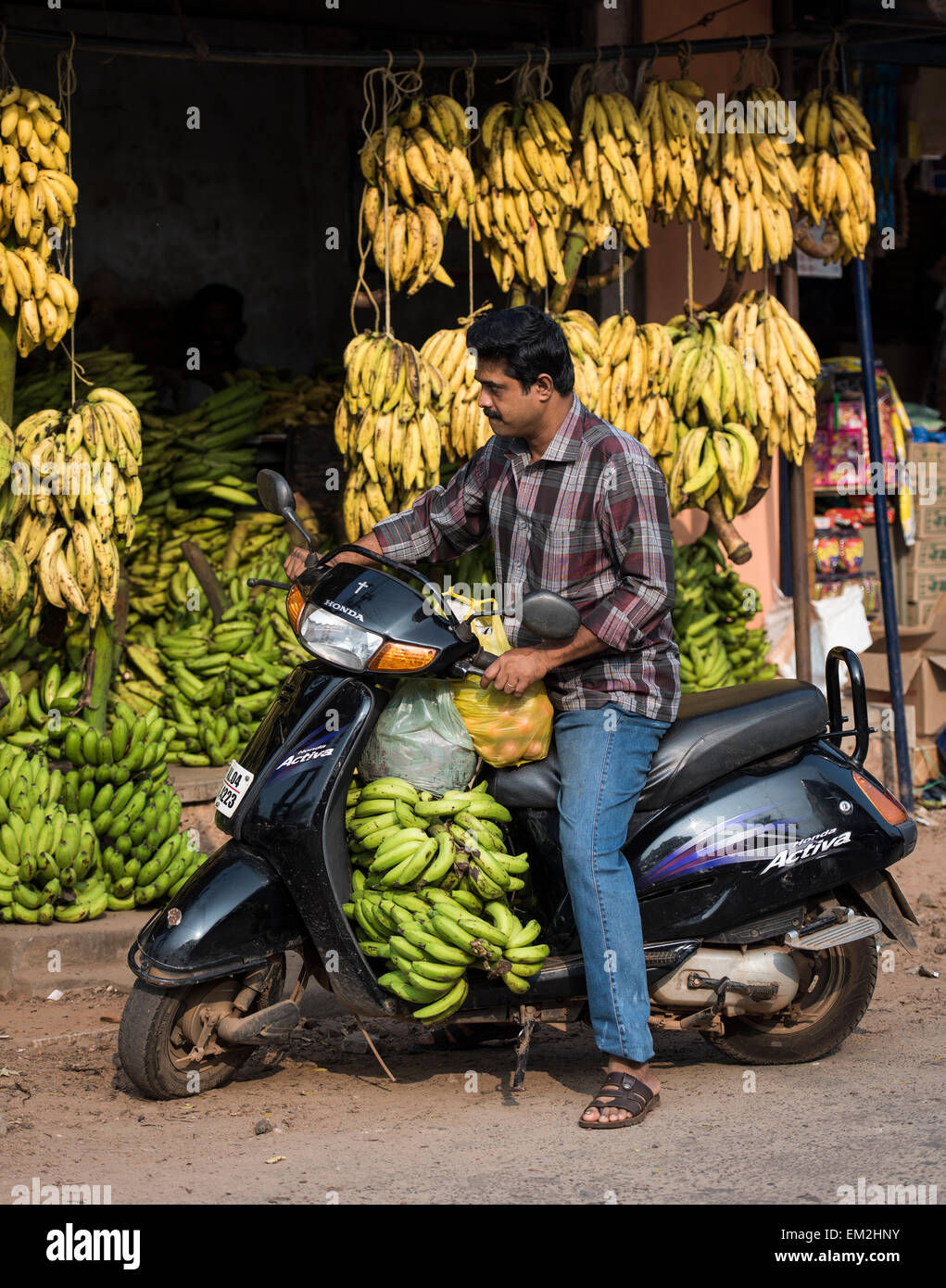 L'homme en scooter par un stand de bananes, Alappuzha District, Kerala, Inde Banque D'Images
