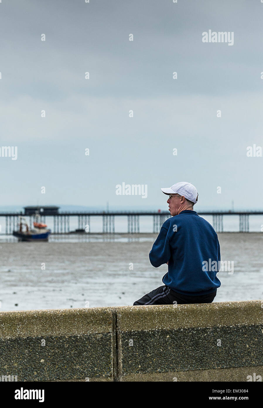 Un homme assis sur son propre sur le front de Southend. Banque D'Images