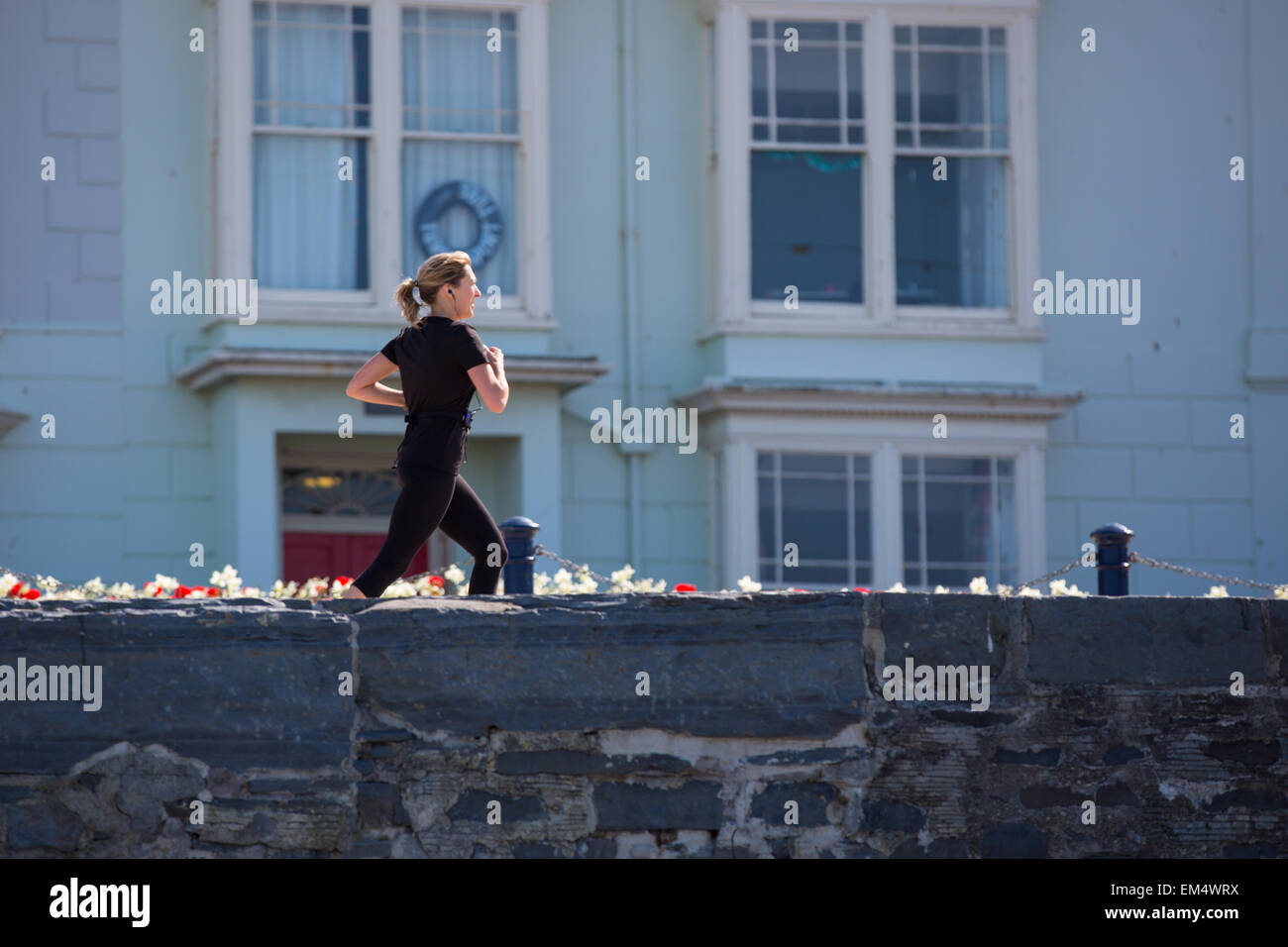 Aberystwyth, Pays de Galles, Royaume-Uni. 16 avril 2015. Météo. Une femme s'exécutant sur Aberystwyth, promenade au soleil Credit : Alan Hale/Alamy Live News Banque D'Images