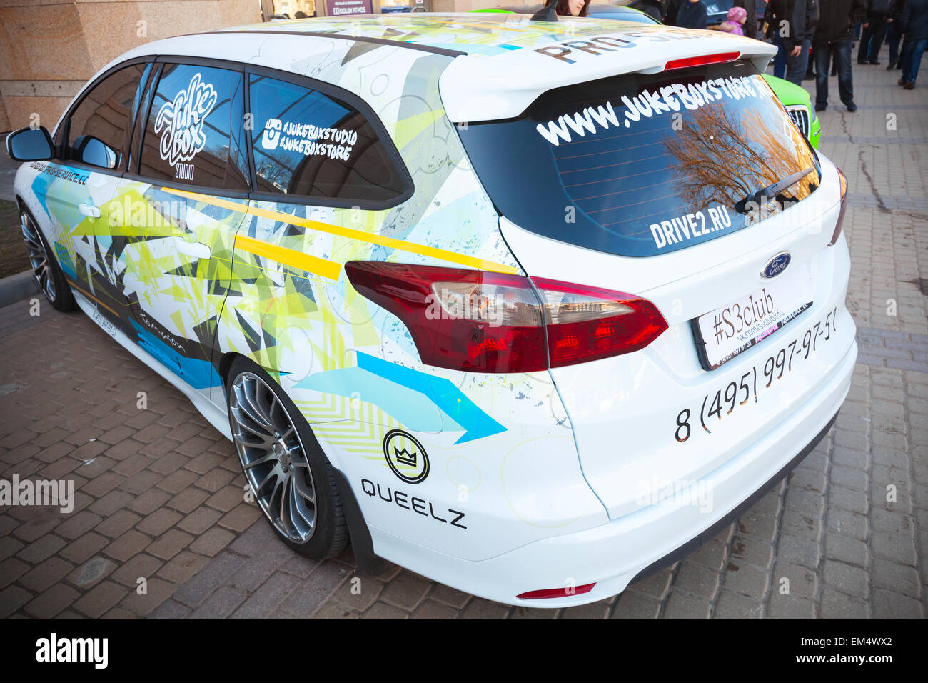 Saint-pétersbourg, Russie - le 11 avril 2015 : Blanc sporty wagon Ford Focus Titanium avec voiture de course se distingue de la peinture colorée parke Banque D'Images