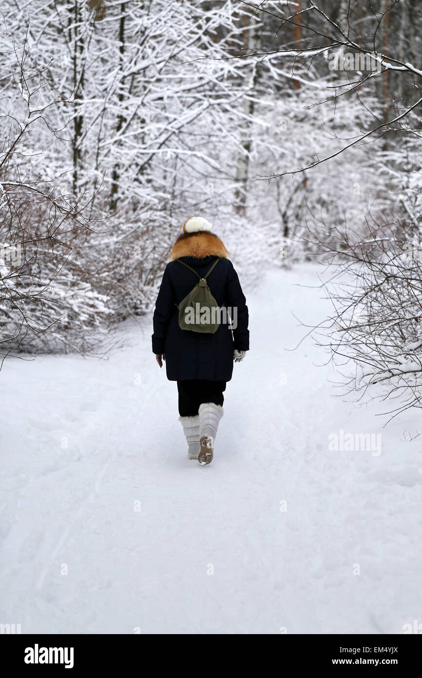 Femme marche dans une forêt enneigée en hiver chemin Banque D'Images