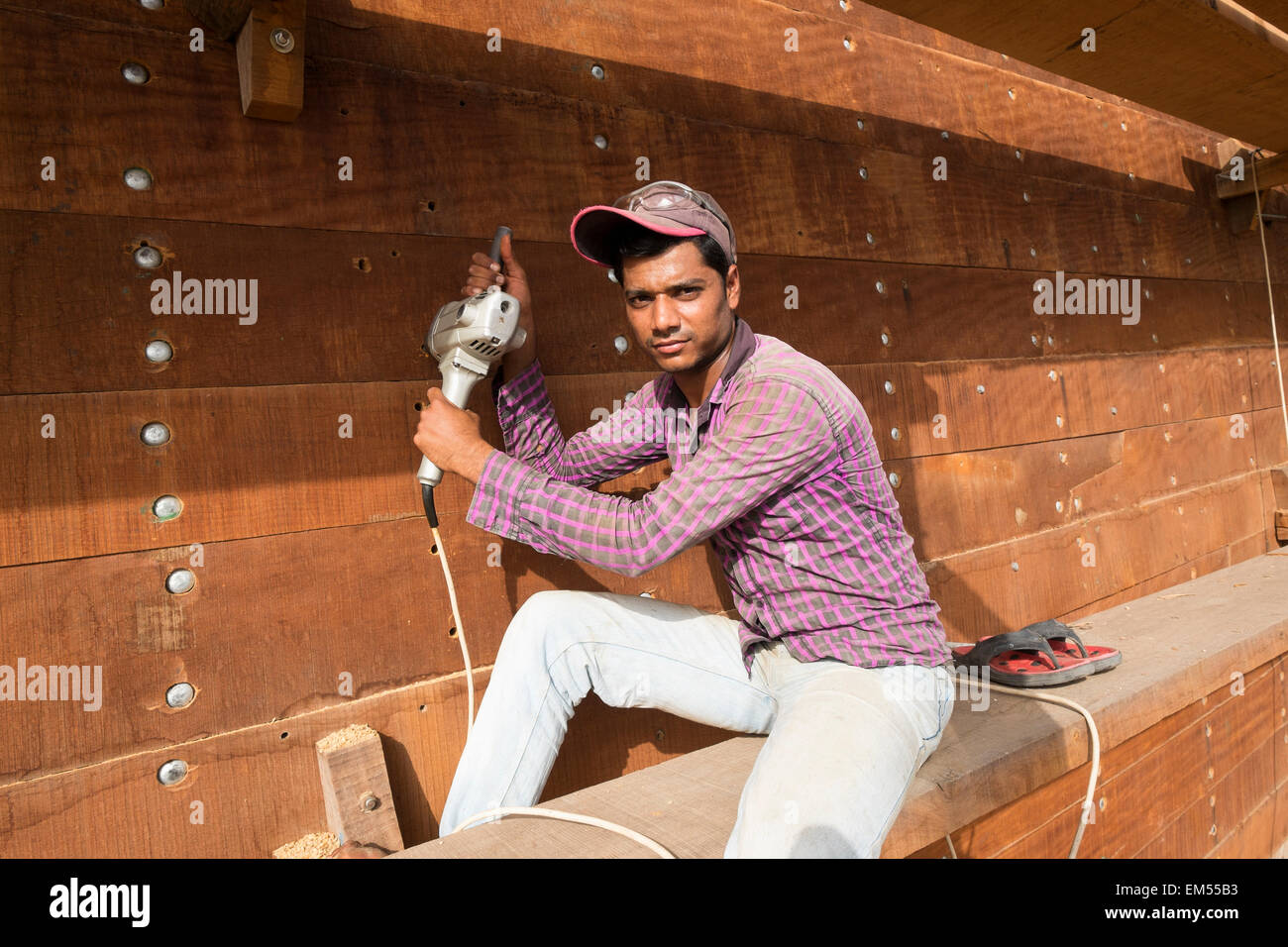 Portrait de la construction d'un travailleur en dhow traditionnel en bois d'un cargo en chantier au bord de la rivière Creek à Dubaï Émirats Arabes Unis Banque D'Images