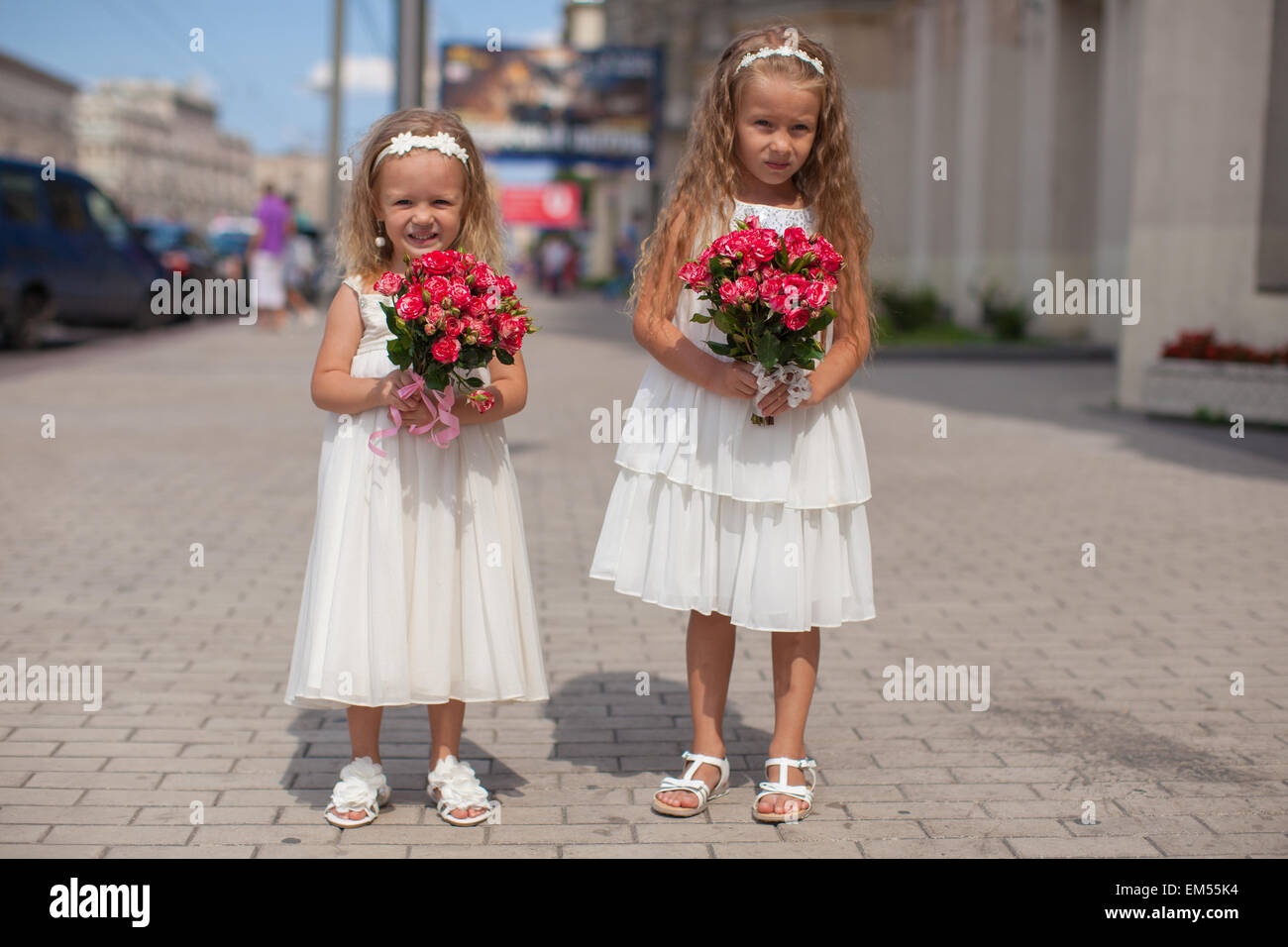 Deux charmantes soeurs avec de magnifiques bouquets de roses dans ses mains vont à la noce Banque D'Images