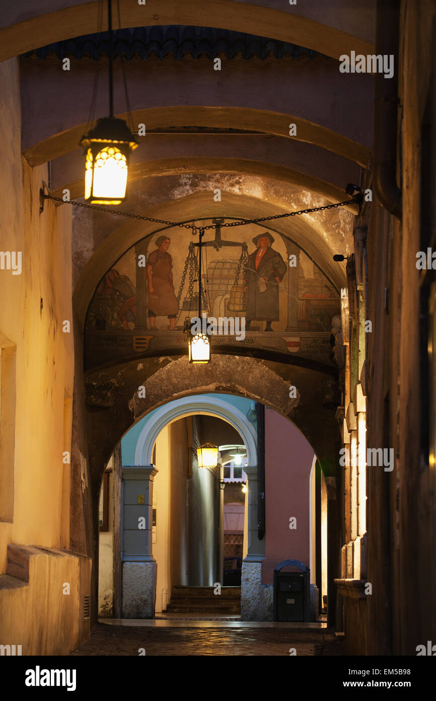 Passage voûté avec fresque et lampadaires la nuit, Bolzano, Alto Adige, Italie Banque D'Images