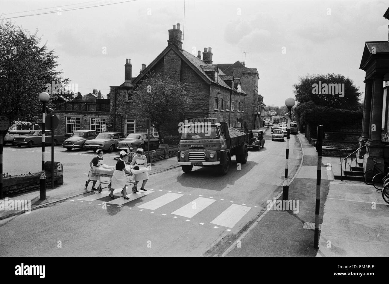 Student Nurse Anne Luce , Nurse Betty de Silva (verres) et Sœur Ruth Miller en traitement d'urgence (avec du sang goutte) dans une rue animée d'un côté de Cirencester Memorial Hospital à l'autre. La Cirencester Memorial Hospital est divisé par une route principale. 21 avril 1966. Banque D'Images