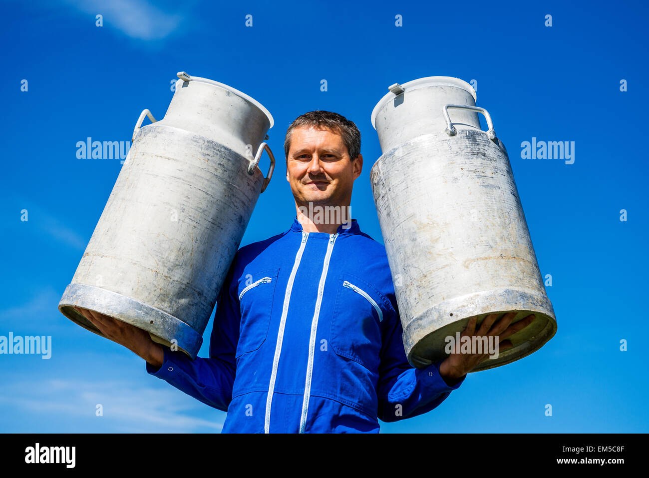 Agriculteur avec les contenants de lait Banque D'Images