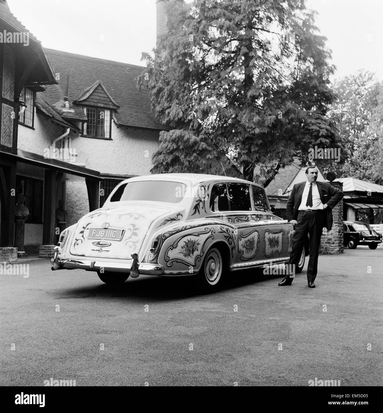 Le chauffeur des Beatles chanteur John Lennon debout à côté de Lennon Rolls Royce avec ses détails décoratifs. Banque D'Images