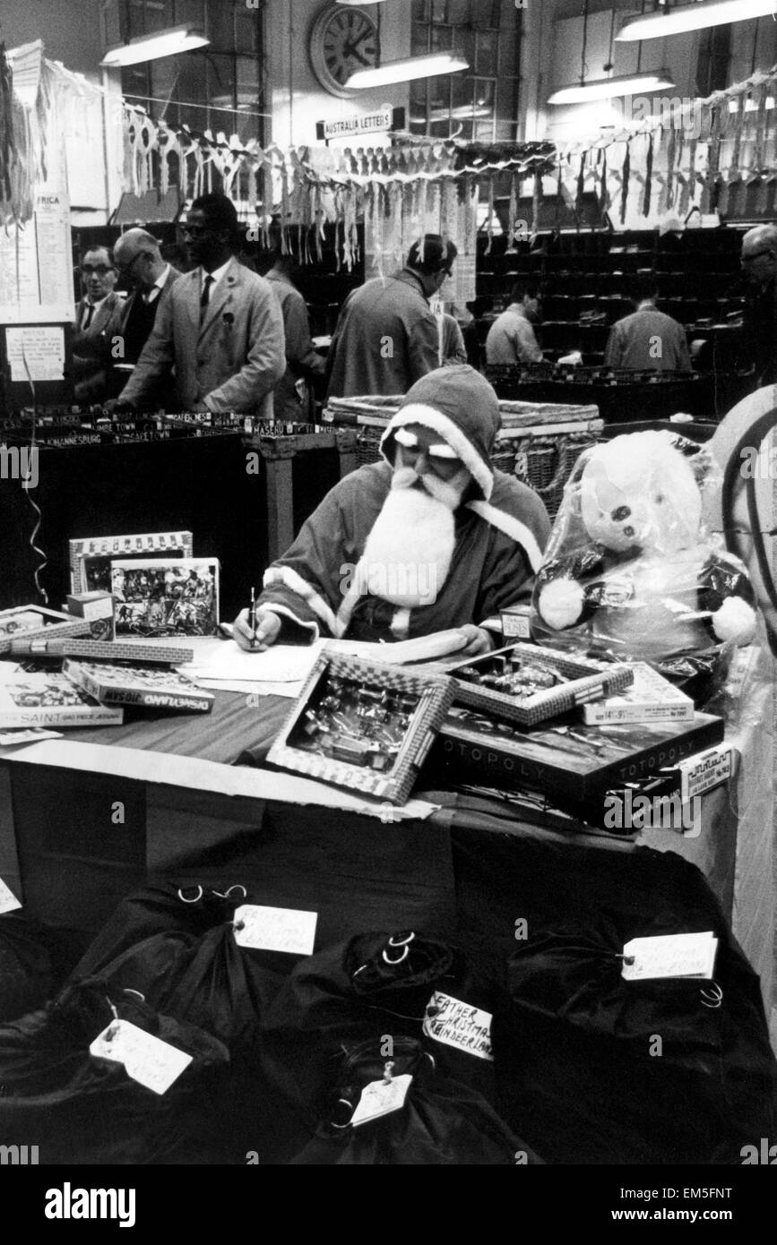 Homme habillé en père Noël dans un bureau de poste. 14 décembre 1966. Banque D'Images