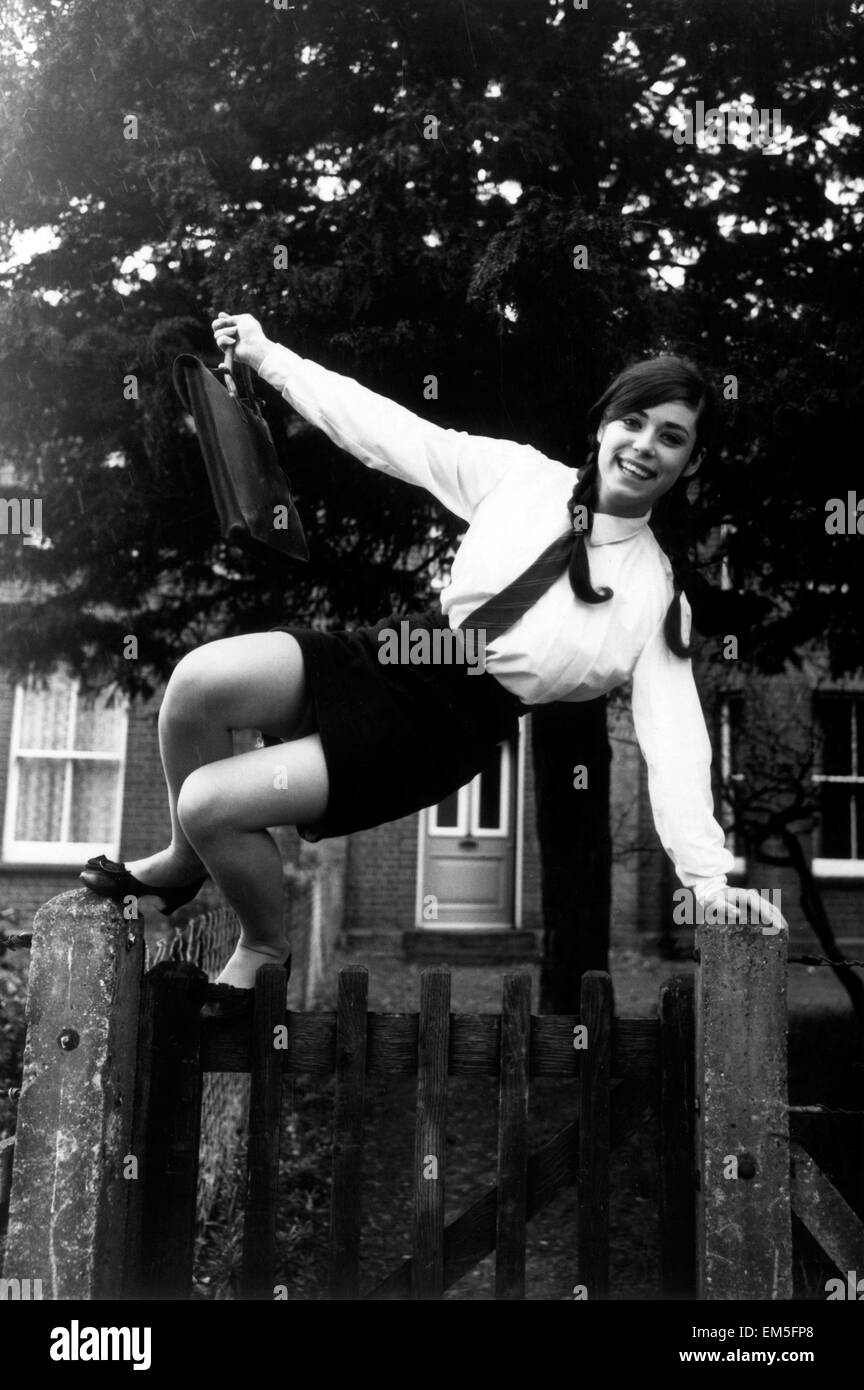 Seize ans Katie Kirke saute par dessus la barrière en allant à l'école, le jour après avoir remporté le concours de beauté annuel au carnaval de Burnham. 27 août 1968. Banque D'Images