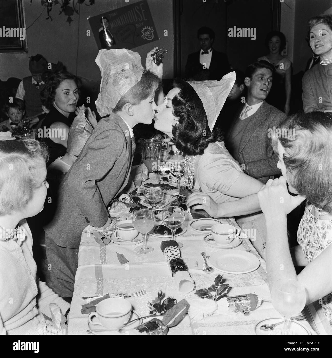 Garçon l'acteur Richard Williams actrice Anne Heywood baisers sur les lèvres sous le gui au Women's Sunday Mirror party de Noël. 22 décembre 1957. Banque D'Images