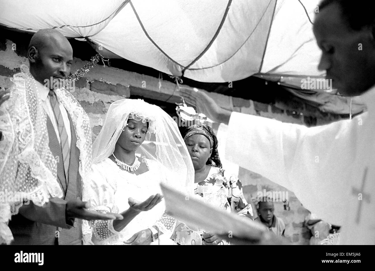 La population catholique de la province rurale de Kitui (Kenya) est d'environ 58  %. Bien que la tradition catholique vient de l'Irlande, le Kenya a sa propre façon de célébrer, mélangé avec d'antiques rituels tribaux, comme Dancing et chants, à la suite par l'ensemble du village. Le livre blanc et la vinaigrette traditionnelle d'un mariage contraste avec la belle peau noire du peuple kenyan, entouré par la ferme conviction des invités. Le prêtre prêche durant la cérémonie. Banque D'Images