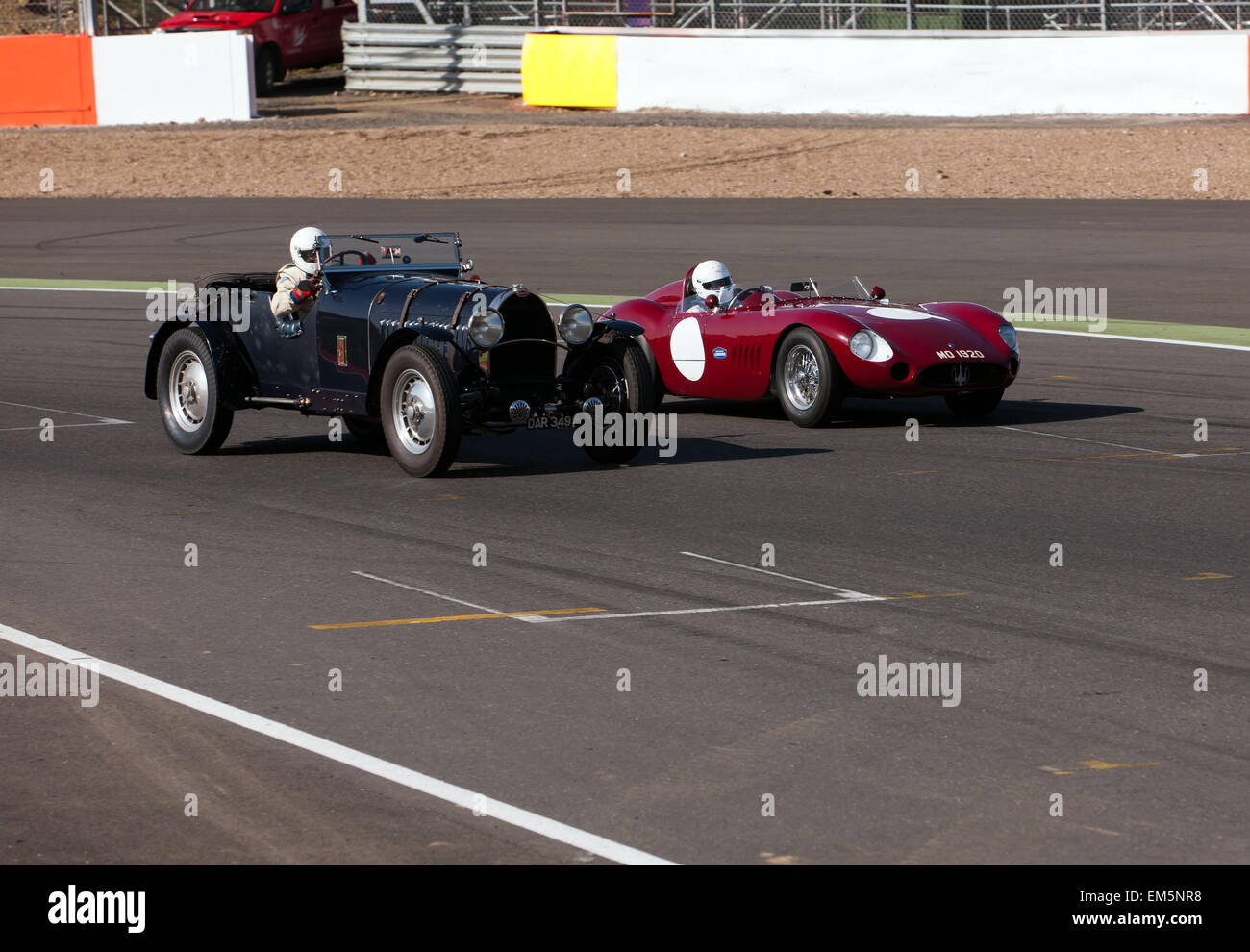 Obtenir pilotes suivre le temps avec leurs voitures de course classique. Une Bugatti et d'une Maserati côte à côte comme ils entrent dans le détroit de finition sur le célèbre circuit de Silverstone. Banque D'Images
