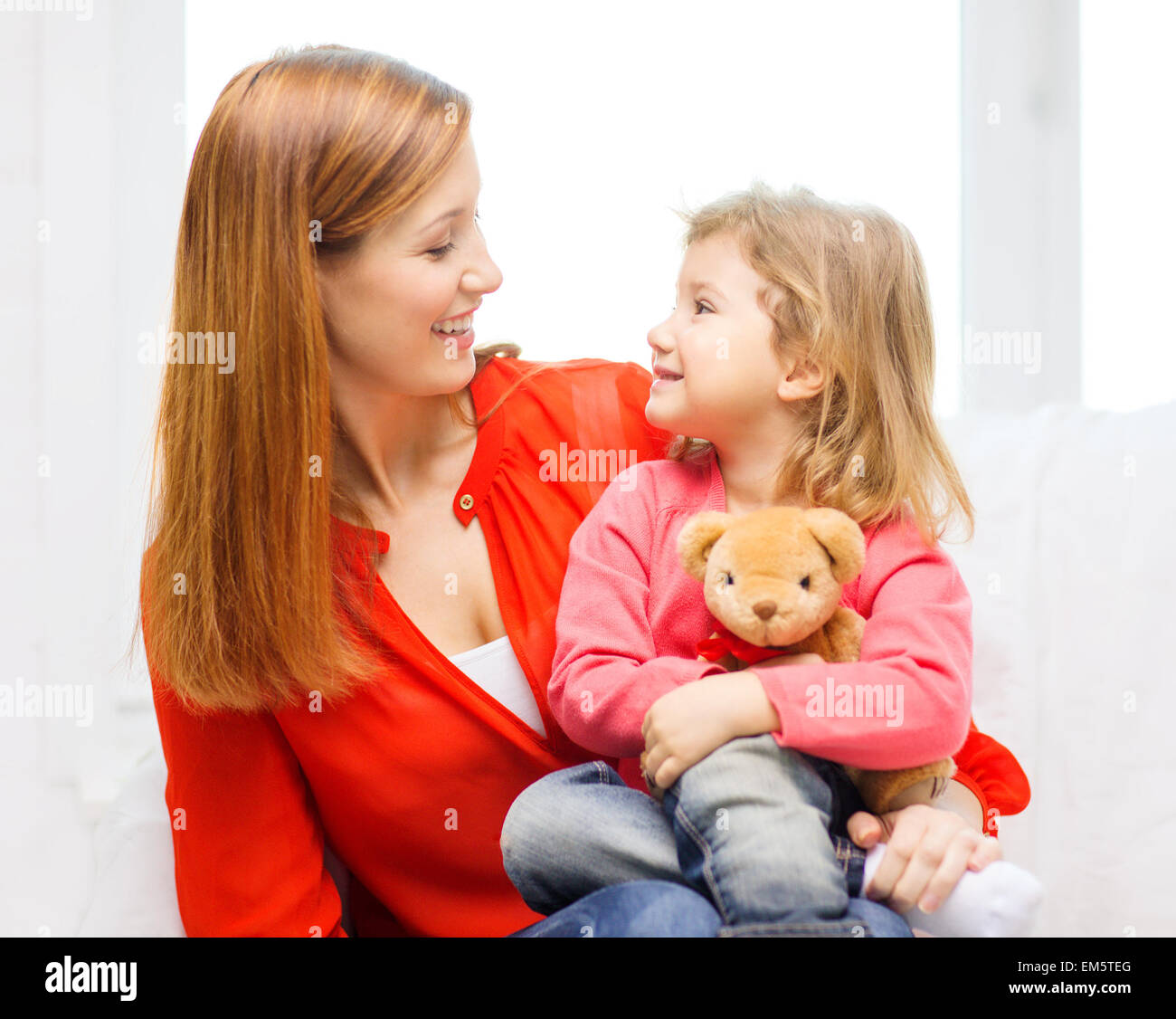 Heureuse Mère et enfant avec ours en peluche à la maison Banque D'Images