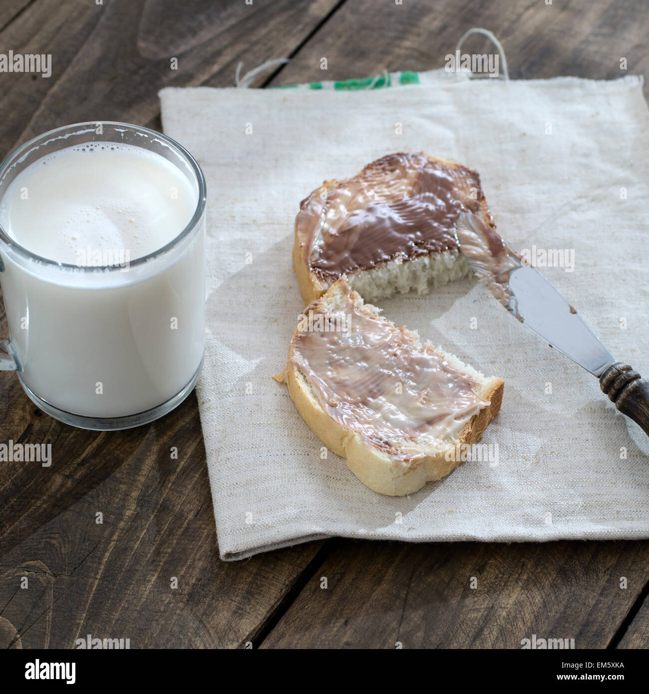 Tranche de pain avec la crème au chocolat et le lait sur la table Banque D'Images