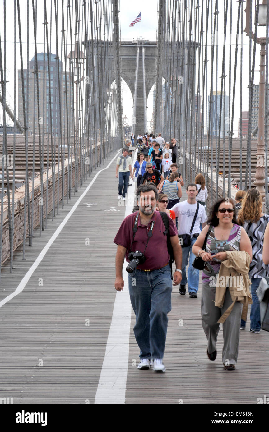Les piétons et les touristes traversant le pont de Brooklyn à New York Banque D'Images