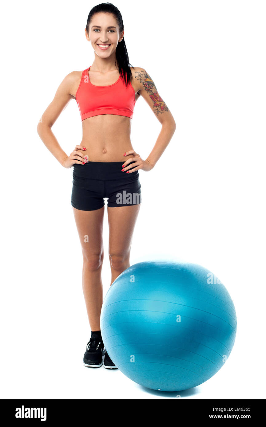 Jeune femme dans la salle de sport de l'usure avec boule d'exercice Banque D'Images