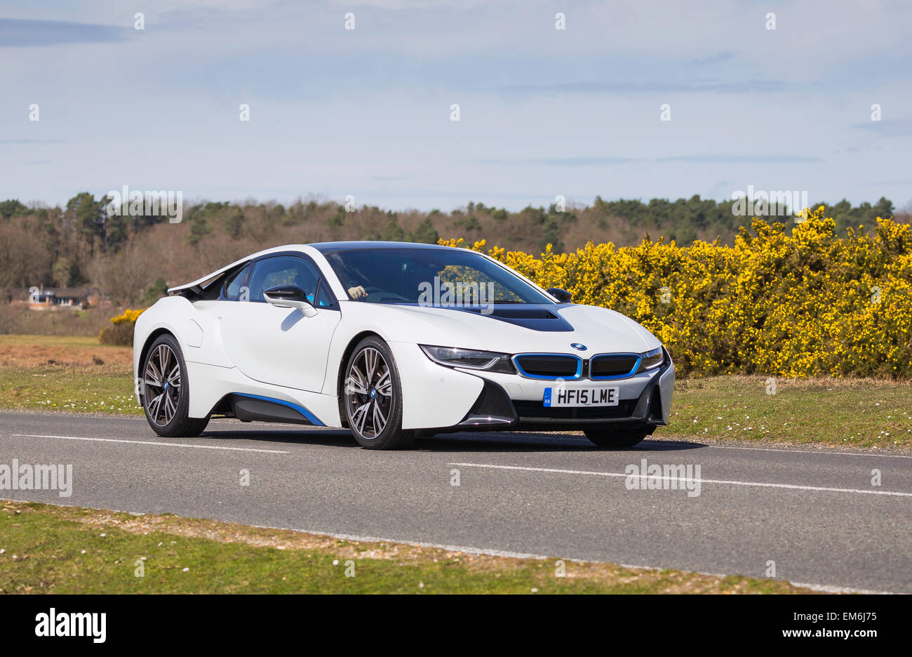 Un livre blanc BMW i8 voiture de sport électrique hybrides classiques, via le Parc National de New Forest sur une journée ensoleillée Banque D'Images