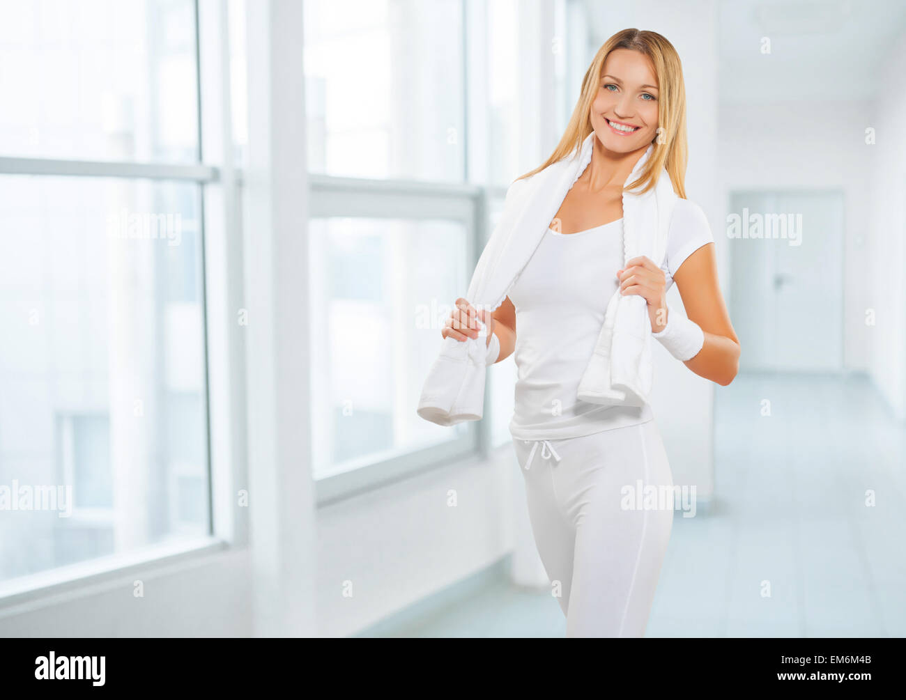 Une femme portant des vêtements de sport de sport avec une serviette blanche cottton Banque D'Images