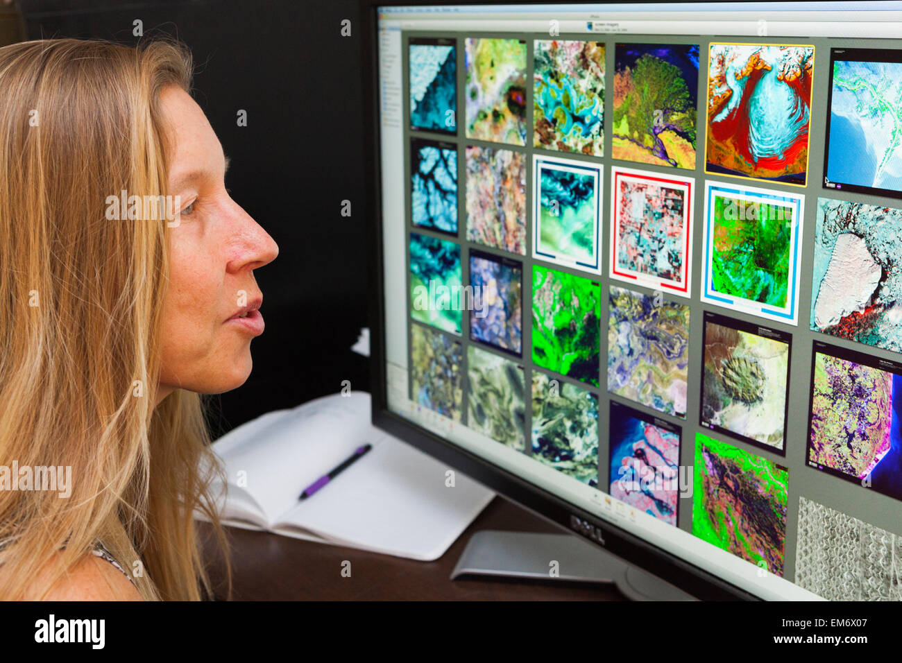 Une femme regarde l'imagerie par satellite de l'Alaska et d'autres régions à un laboratoire de télédétection à Boulder, Colorado. Banque D'Images