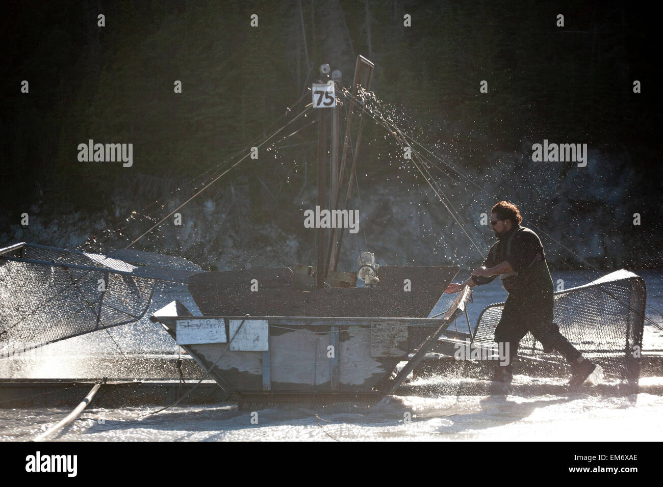 Un homme travaille sur sa famille, sur la roue des poissons, près de Copper River, Alaska Chitina. Banque D'Images