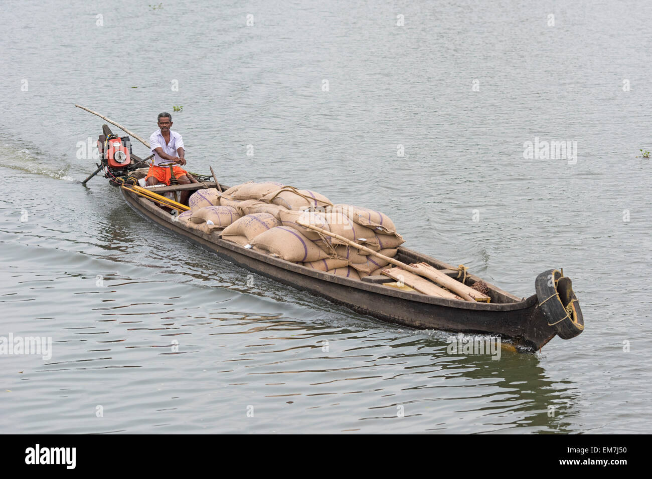 Un bateau de l'homme chargés de sacs, système de canaux dans les Backwaters Alappuzha, Kerala, Inde Banque D'Images