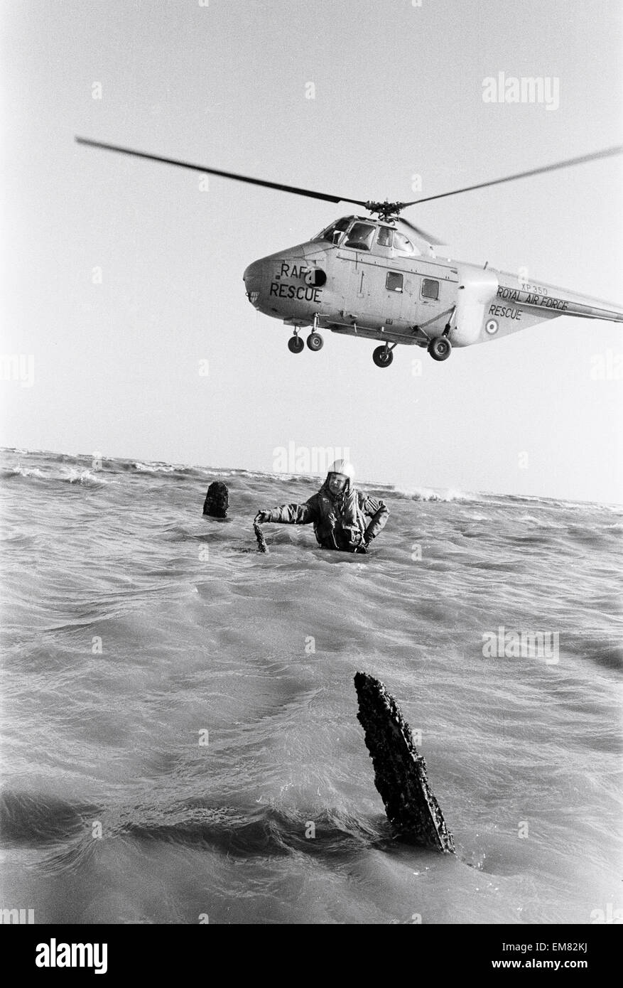 Navigateur maître Colin Walsh de la RAF Air Sea Rescue Service est à la  hauteur de la taille dans l'eau sur un banc de sables bitumineux à Goodwin,  tout près de la