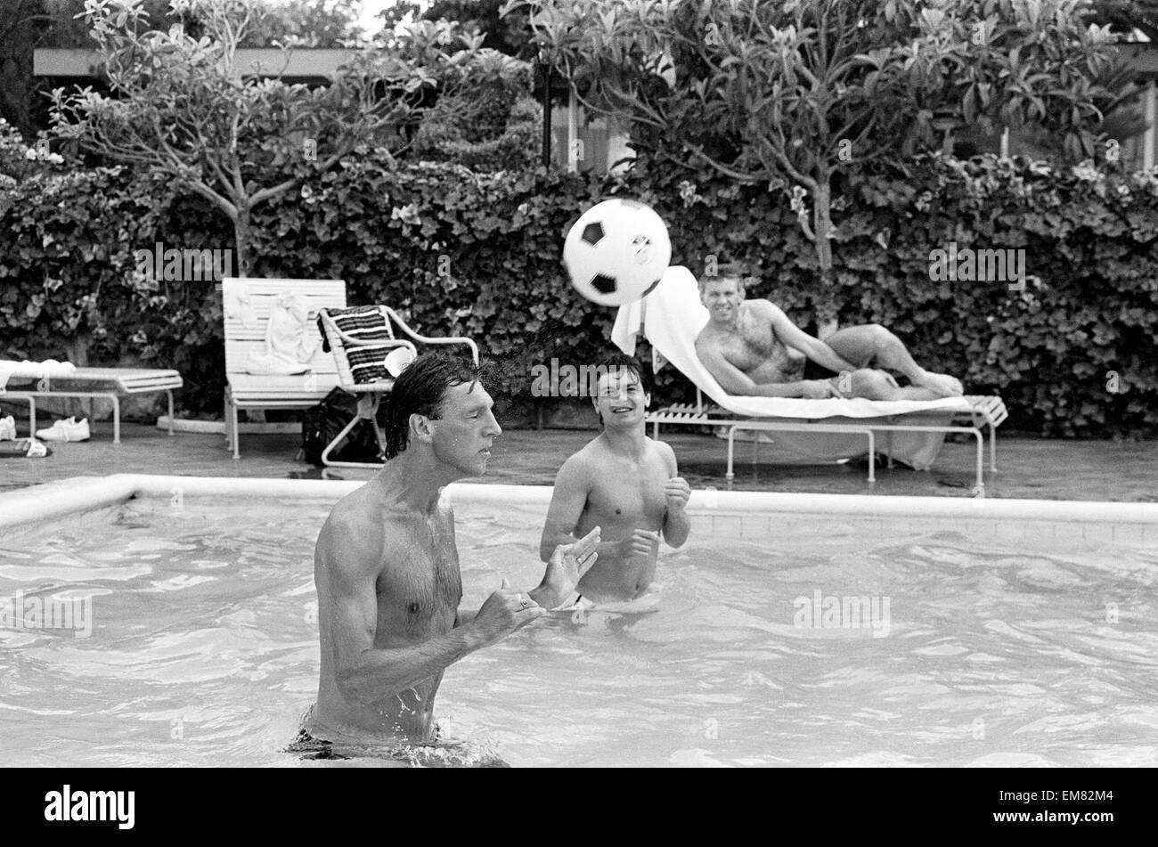Footballeurs Angleterre Alvin Martin (à gauche) et Steve Hodge chef jeu pong dans la piscine à la Cima Club à Monterrey, au Mexique, où l'équipe de l'Angleterre sont fondées avant la Coupe du Monde 1986. À la recherche d'une chaise longue sur le côté de la piscine est Peter Reid. 27 mai 1986. Banque D'Images