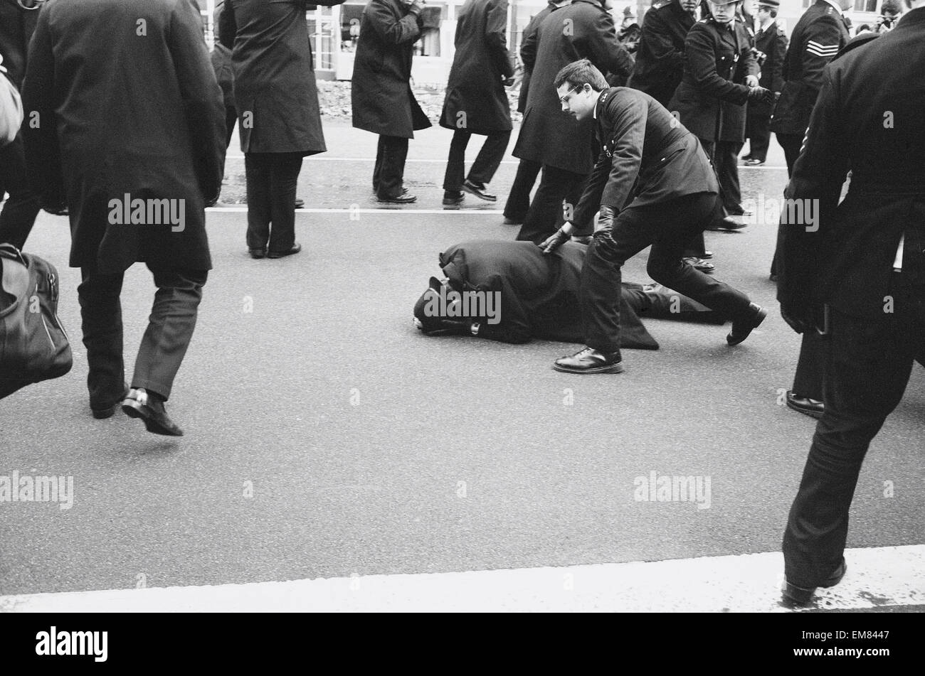 La violence a éclaté alors que des milliers de manifestants en colère ont défilé à Londres pour protester contre la police de la manipulation de l'enquête sur un incendie à Deptford où 13 personnes sont mortes. noir Un agent de police s'occupe d'un collleague après qu'il a été blessé au cours de l'affrontement sur Blackfriars Bridge Road. 2 mars 1981. Banque D'Images