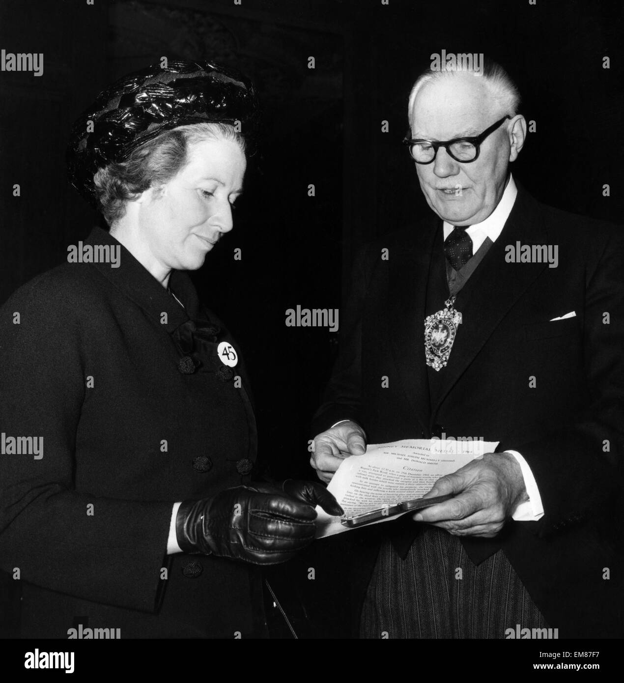 Fière mère Mme Munnelly reçoit le premier octroi à titre posthume de la médaille d'orfévrerie Binney Hall Londres 6 décembre 1965. Son fils, Michael Munnelly 23 était un dimanche, les gens journaliste qui a été assassiné par un jeune de 18 ans boucher cutter, alors que de rendre visite à sa famille à Londres, décembre 1964. Michael Munnelly est mort tout en défendant un laitier de plus d'une douzaine de malfrats. Banque D'Images