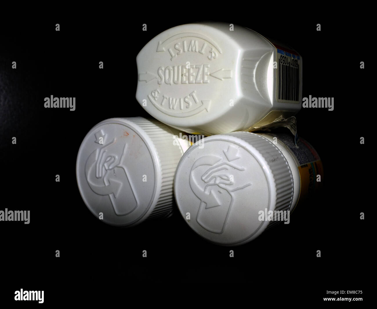 Les emballages protège-enfants sur les bouteilles de comprimés de vitamine a photographié sur un fond noir. Banque D'Images