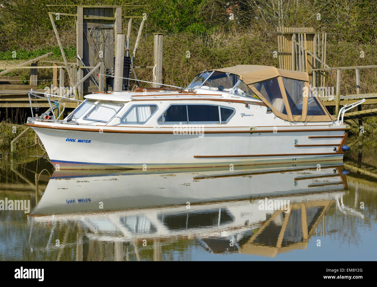Seamaster 27 petit bateau amarré sur une rivière avec son reflet dans l'eau. Banque D'Images